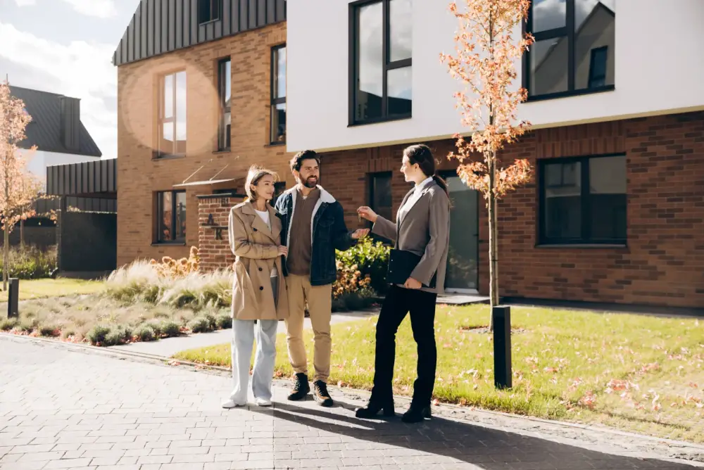 Real estate agent handing keys to new homeowners